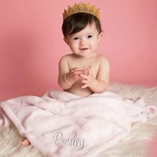 little baby girl wearing a crown snuggled in her pink personalized monogrammed blanket with her name Presley