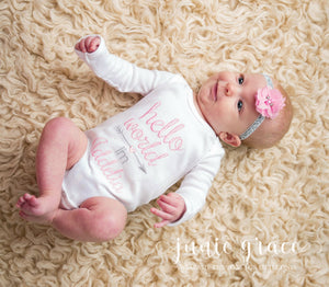 Baby wearing a pink and white romper personalized with her name Mila